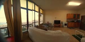 a living room with a couch and a large window at Amazing Panorama Bay view 3 room flat in Haifa