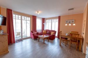 a living room with a red couch and a table at Villa-Senta-Apartment-10 in Kühlungsborn