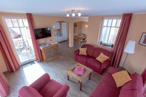 a living room with two purple couches and a tv at Villa-Senta-Apartment-11 in Kühlungsborn