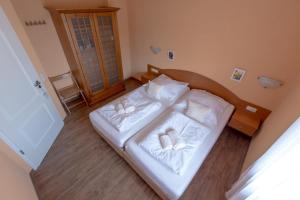 a bedroom with two beds with white sheets at Villa-Senta-Apartment-11 in Kühlungsborn