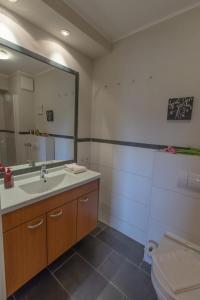 een badkamer met een wastafel, een toilet en een spiegel bij Villa-Senta-Apartment-12 in Kühlungsborn