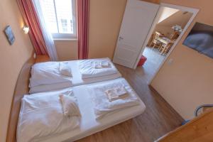 a small bedroom with two beds and a mirror at Villa-Senta-Apartment-13 in Kühlungsborn