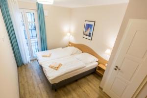 um pequeno quarto com uma cama com dois livros em Sunnevelt-Apartment-9 em Kühlungsborn