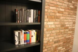 uma estante cheia de livros ao lado de uma parede de tijolos em Sunnevelt-Apartment-9 em Kühlungsborn