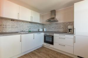 a white kitchen with white cabinets and a sink at Sunnevelt-Apartment-10 in Kühlungsborn
