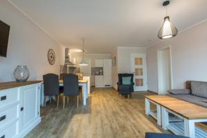 Sunnevelt-Apartment-12 في كولونغسبورن: مطبخ وغرفة معيشة مع طاولة وكراسي