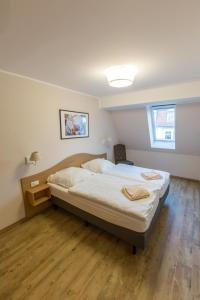 Sunnevelt-Apartment-12 في كولونغسبورن: غرفة نوم بسرير كبير مع أرضية خشبية