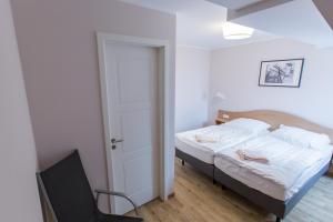 a bedroom with a bed and a chair in it at Sunnevelt-Apartment-18 in Kühlungsborn