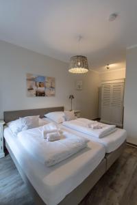 - 2 lits blancs dans une chambre dotée d'un lustre dans l'établissement Villa-Borwin-Apartment-12, à Kühlungsborn