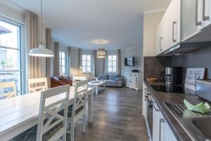 cocina y sala de estar con mesa y sillas en Villa-Borwin-Apartment-10, en Kühlungsborn