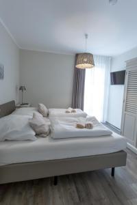 a large white bed in a bedroom with a chandelier at Villa-Borwin-Apartment-9 in Kühlungsborn