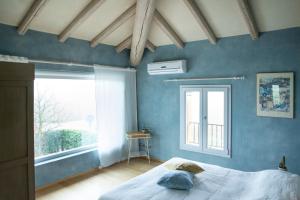 Dormitorio azul con cama y ventana en * * * * * Splendida casa di campagna, en Castenaso