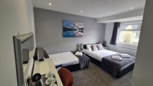Habitación de hotel con 2 camas y espejo en Y Gwynedd Inn en Llanberis