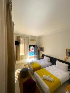 Habitación de hotel con 2 camas y ventana en Majorel Perle Hôtel Riad Restaurant Picine & Spa, en Marrakech