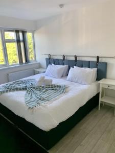 une chambre avec un grand lit et une tête de lit bleue dans l'établissement Cosy 2 bedrooms apartment in Birmingham, à Birmingham