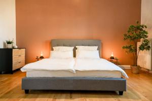 a bedroom with a large bed with orange walls at 120qm Denkmal Apartment in Krefeld mit Stuck und Balkon - BEUYS Apartments - Krefeld in Krefeld
