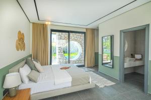 een slaapkamer met een groot bed en een badkamer bij Viohouses - Luxury Private Pool Villas Fethiye in Fethiye