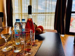 een fles wijn en glazen op een tafel bij At the American's Hotel in Pomorie