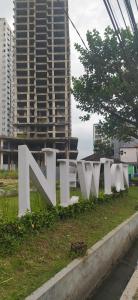 een groot wit bord in het gras in een stad bij Newton Apartment Residence By Ayulian in Bandung