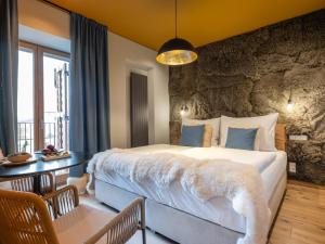 a bedroom with a large bed and a table with chairs at Oblík Resort in Louny