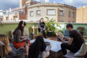 grupa ludzi siedzących na dachu z laptopami w obiekcie Onefam Sants w Barcelonie