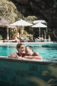 烏魯瓦圖的住宿－烏魯瓦圖別墅酒店，游泳池里的男人和女人