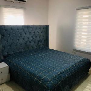 a bed in a room with a blue comforter at Beautiful 4-Bedroom House in Ogombo