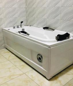 a white bath tub sitting in a room at Beautiful 4-Bedroom House in Ogombo