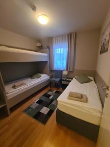 two beds in a room with two bunk beds at Apartment Residence Marina Portorož LEVANT 203 in Portorož