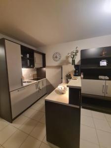 una cucina con elettrodomestici in bianco e nero e un orologio di Apartment Residence Marina Portorož LEVANT 203 a Portoroz