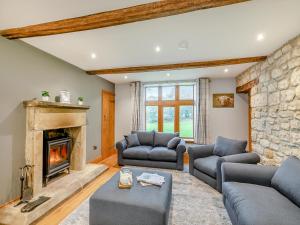 a living room with two couches and a fireplace at Buntingfield Farmhouse in Ashover