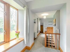 a hallway with a staircase and a window at Buntingfield Farmhouse in Ashover