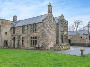 an old brick building with two chairs in front of it at Buntingfield Farmhouse in Ashover