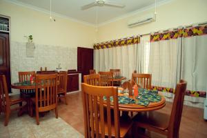 a dining room with wooden tables and chairs at La Casa Preciosa in Tanga