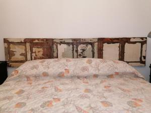 a bed in a room with a wall with chipped at Princess House Palermo - Intero Appartamento - Mondello in Mondello
