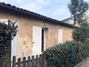 een huis met een witte deur en een hek bij Echoppe Bordelaise chaleureuse in Bordeaux