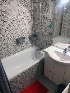 a bathroom with a sink and a bath tub and a toilet and sink at Echoppe Bordelaise chaleureuse in Bordeaux