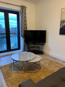 a living room with a flat screen tv and a coffee table at 2 Bed Gated Apartment Westport in Westport