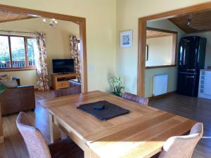 a dining room with a wooden table and chairs at Tawny Lodge with Hot Tub in Cupar