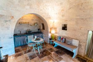 マルティナ・フランカにあるWePuglia - Trullo Meravigliosoのキッチン、ダイニングルーム(石壁のテーブル付)
