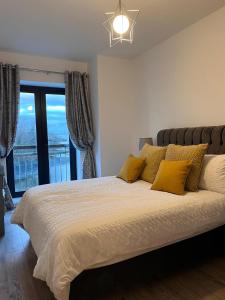 a bedroom with a bed with yellow pillows and a window at 2 Bed Gated Apartment Westport in Westport