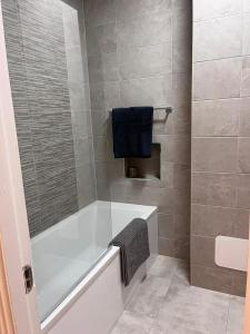 a bathroom with a white bath tub and a blue towel at 2 Bed Gated Apartment Westport in Westport