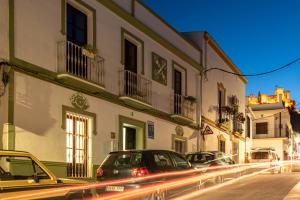 a group of cars parked on a street with buildings at La Casona Verde in Almodóvar del Río