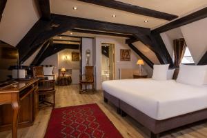Hotel Restaurant Le Maréchal - Teritoria في كولمار: غرفة نوم بسرير ابيض كبير ومطبخ