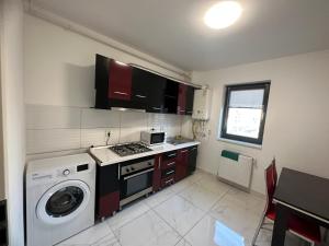 Il comprend une cuisine équipée d'une cuisinière et d'un lave-linge. dans l'établissement Apartament Elena, à Bragadiru