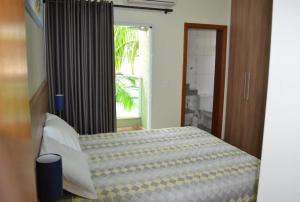 1 dormitorio con cama y ventana grande en Residencial Flat Villa Rosa, en Itapetininga
