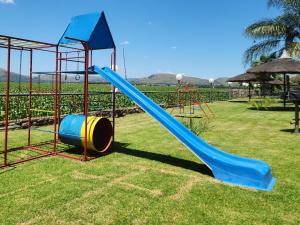 a playground with a slide on the grass at Kosmos, Hartbeespoort in Hartbeespoort