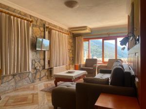 a living room with two couches and a television at Villa Symbola in Oludeniz