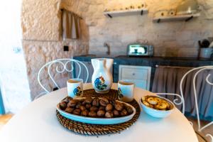 マルティナ・フランカにあるWePuglia - Trullo Meravigliosoのテーブルの上に食べ物の入った皿とボウル