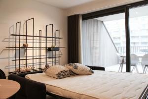 a bedroom with a bed and a large window at Crystal Residences - Luxurious Seaside Apartments in Ostend